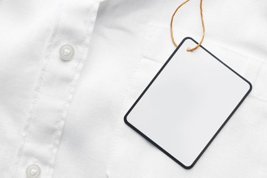 Cardboard tag with space for text on white shirt, top view