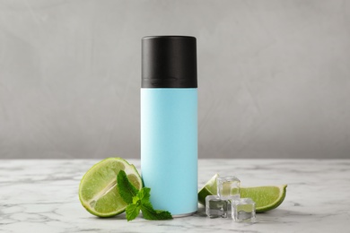 Natural spray deodorant, lime and ice on marble table