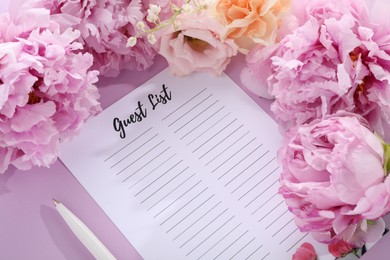 Photo of Guest list, pen and beautiful flowers on violet background, above view
