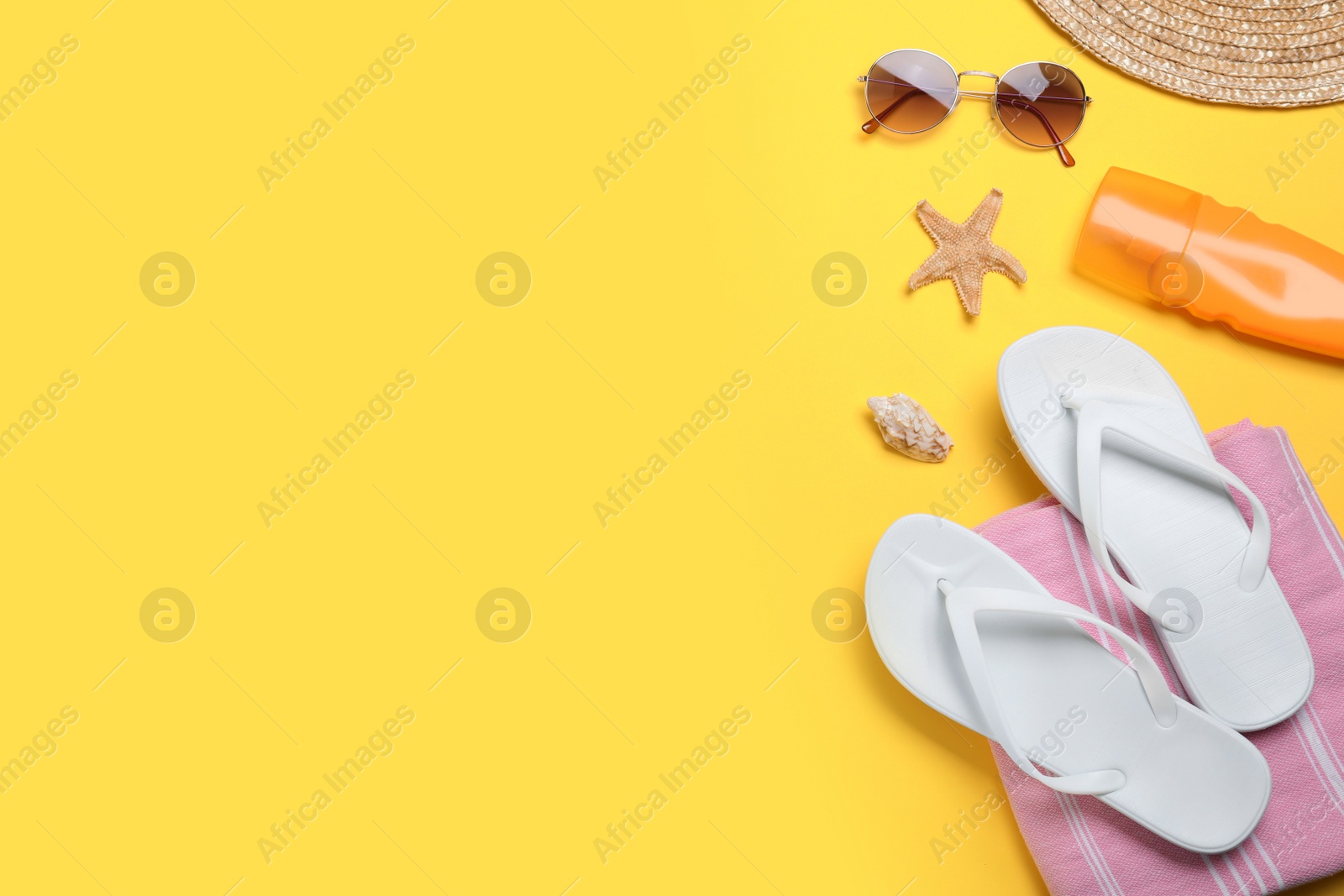 Photo of Stylish flip flops and beach objects on yellow background, flat lay. Space for text