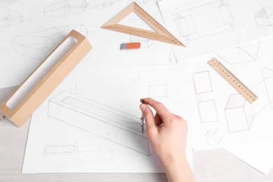 Photo of Man creating packaging design at light wooden table, above view