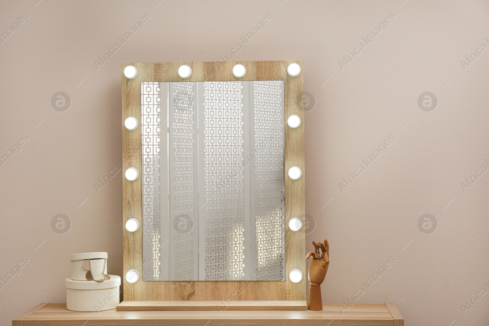 Photo of Stylish mirror with light bulbs near beige wall