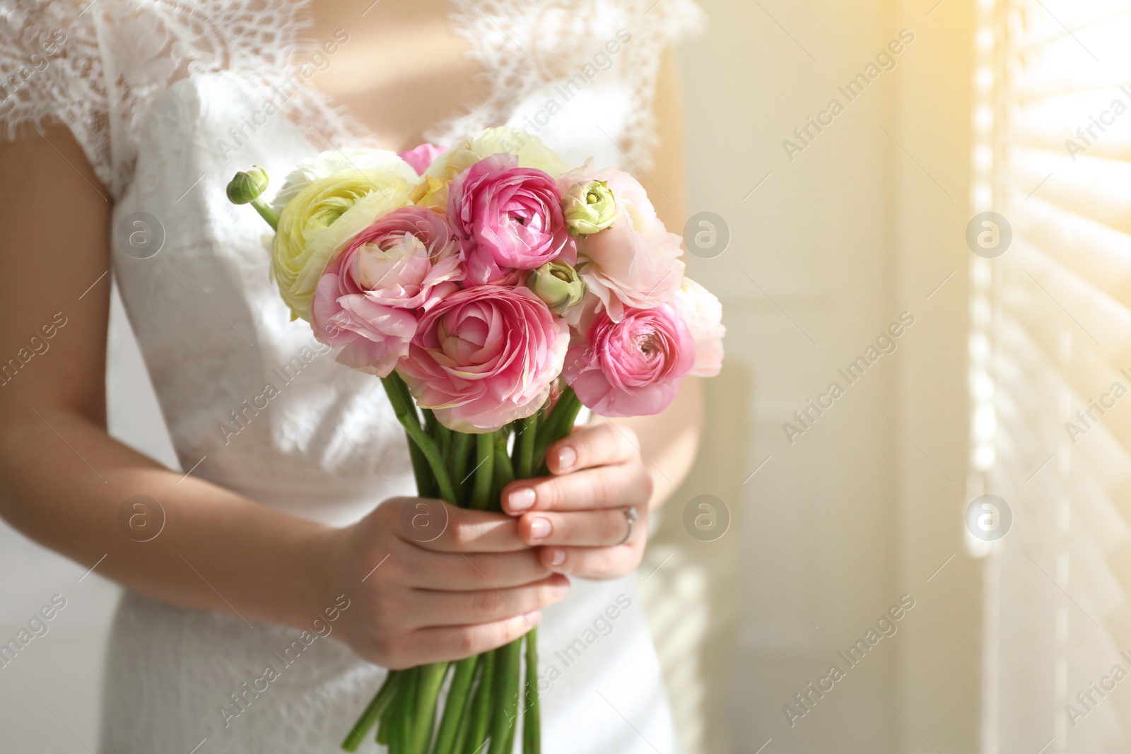 Photo of Bride with beautiful ranunculus bouquet indoors, closeup. Space for text