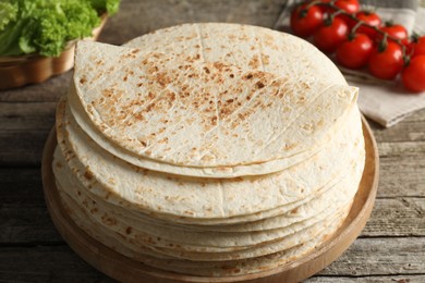 Photo of Stack of tasty homemade tortillas on wooden table