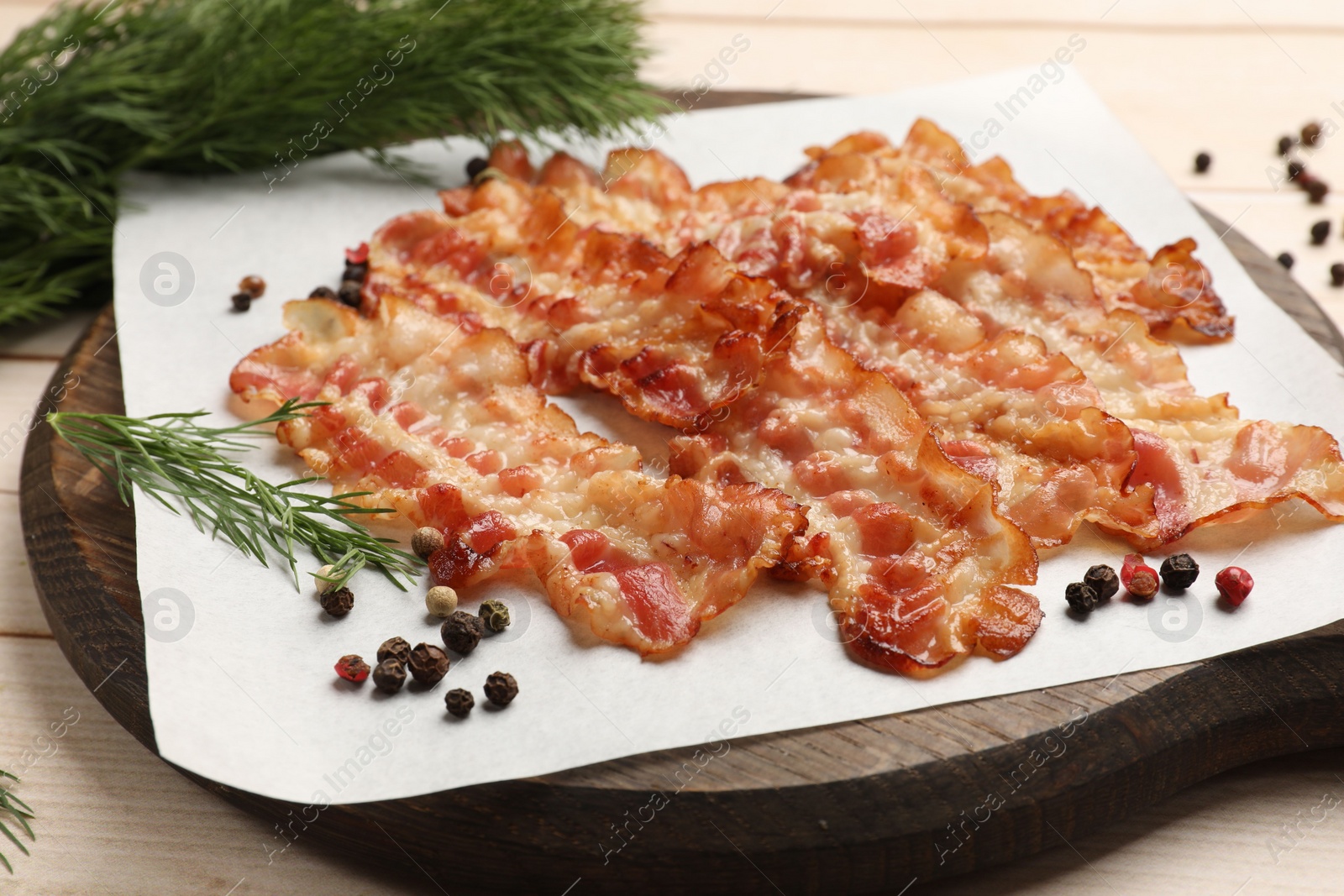 Photo of Delicious fried bacon slices on white wooden table, closeup