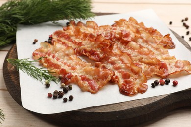 Delicious fried bacon slices on white wooden table, closeup