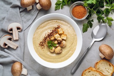 Delicious cream soup with mushrooms and croutons on beige textured table, flat lay