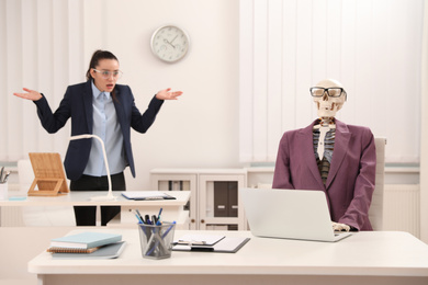 Photo of Young woman working with skeleton in office