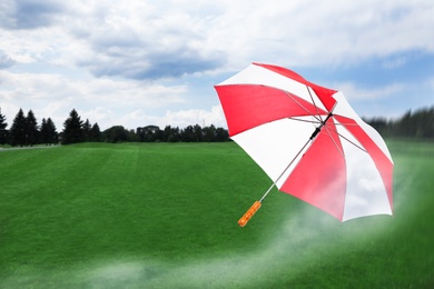 Image of Open umbrella blown by wind gust outdoors