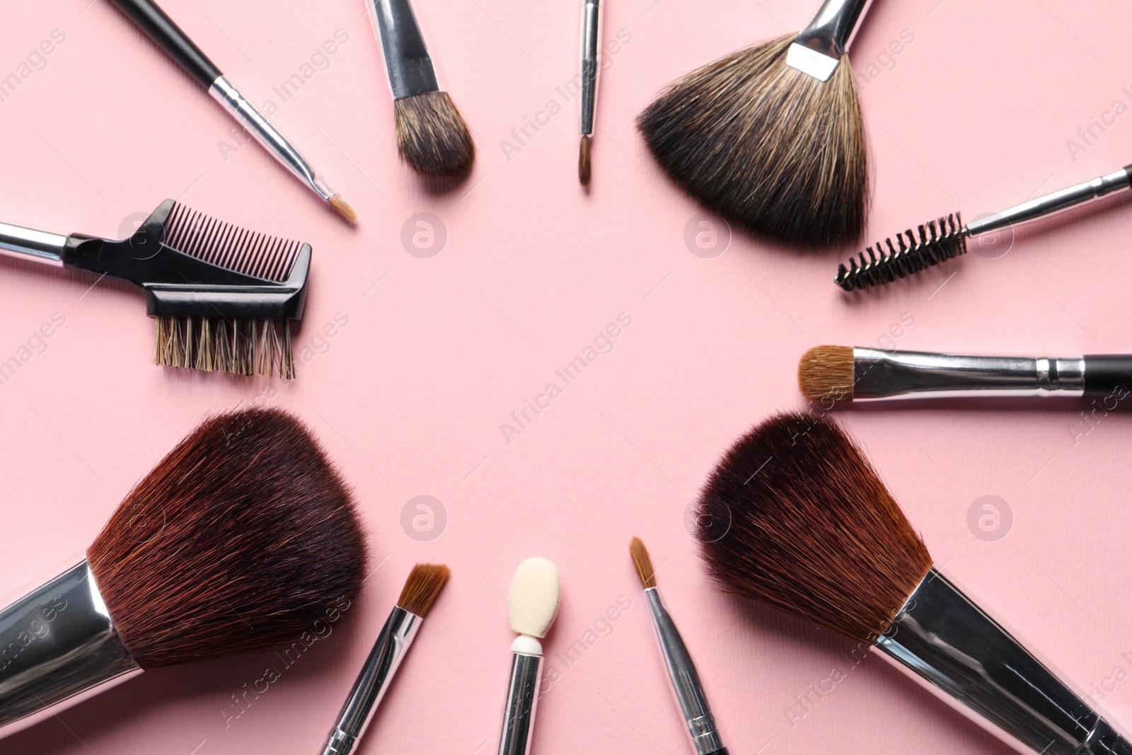 Photo of Frame of different makeup brushes on pink background, flat lay. Space for text