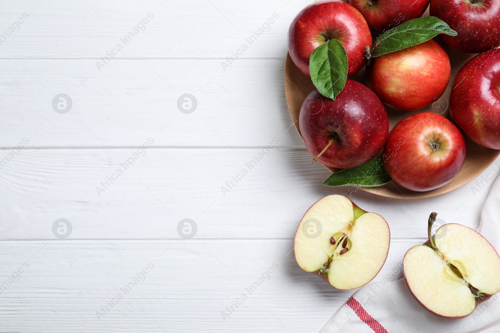 Photo of Juicy red apples on white wooden table, flat lay. Space for text