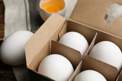 Photo of Fresh raw chicken eggs in box on table, closeup