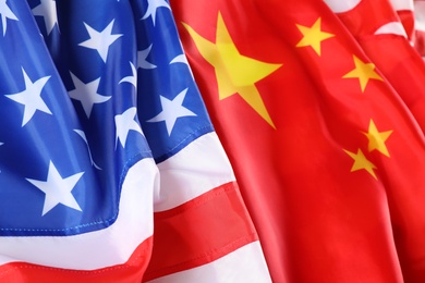 Photo of USA and China flags as background, closeup. International relations