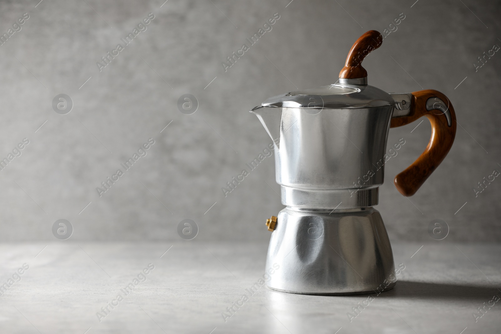 Photo of Brewing coffee. Moka pot on light grey table, space for text