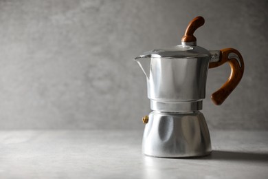 Photo of Brewing coffee. Moka pot on light grey table, space for text