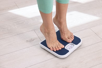 Photo of Woman on floor scale at home, closeup. Space for text