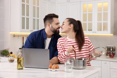 Photo of Happy lovely couple enjoying time together while cooking in kitchen