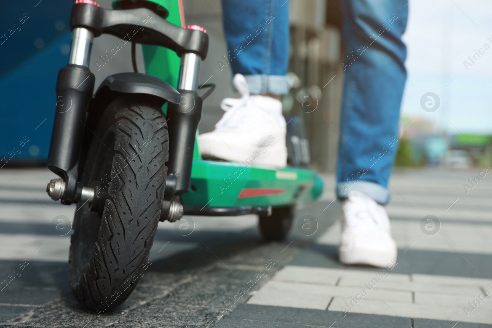 Photo of Woman with modern electric kick scooter outdoors, closeup