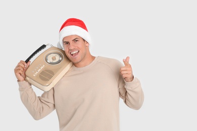 Photo of Emotional man with vintage radio on white background, space for text. Christmas music