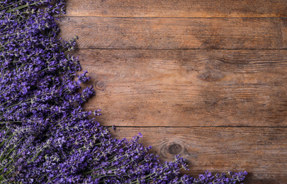 Photo of Beautiful lavender flowers on wooden background, flat lay. Space for text