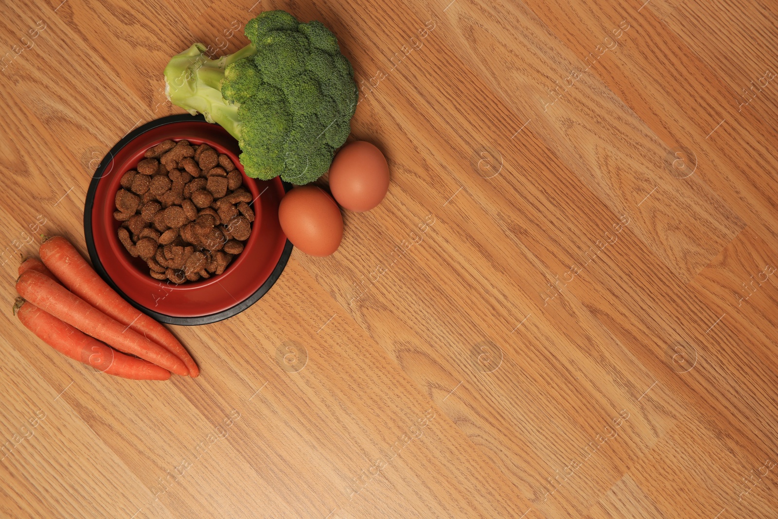 Photo of Dry pet food and products on wooden background, flat lay. Space for text