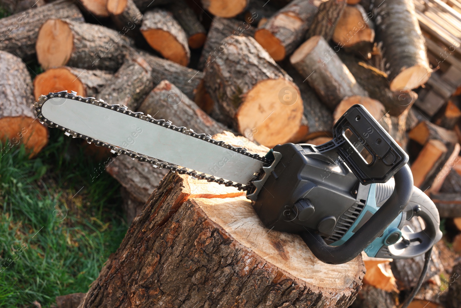 Photo of One modern saw on wooden log outdoors