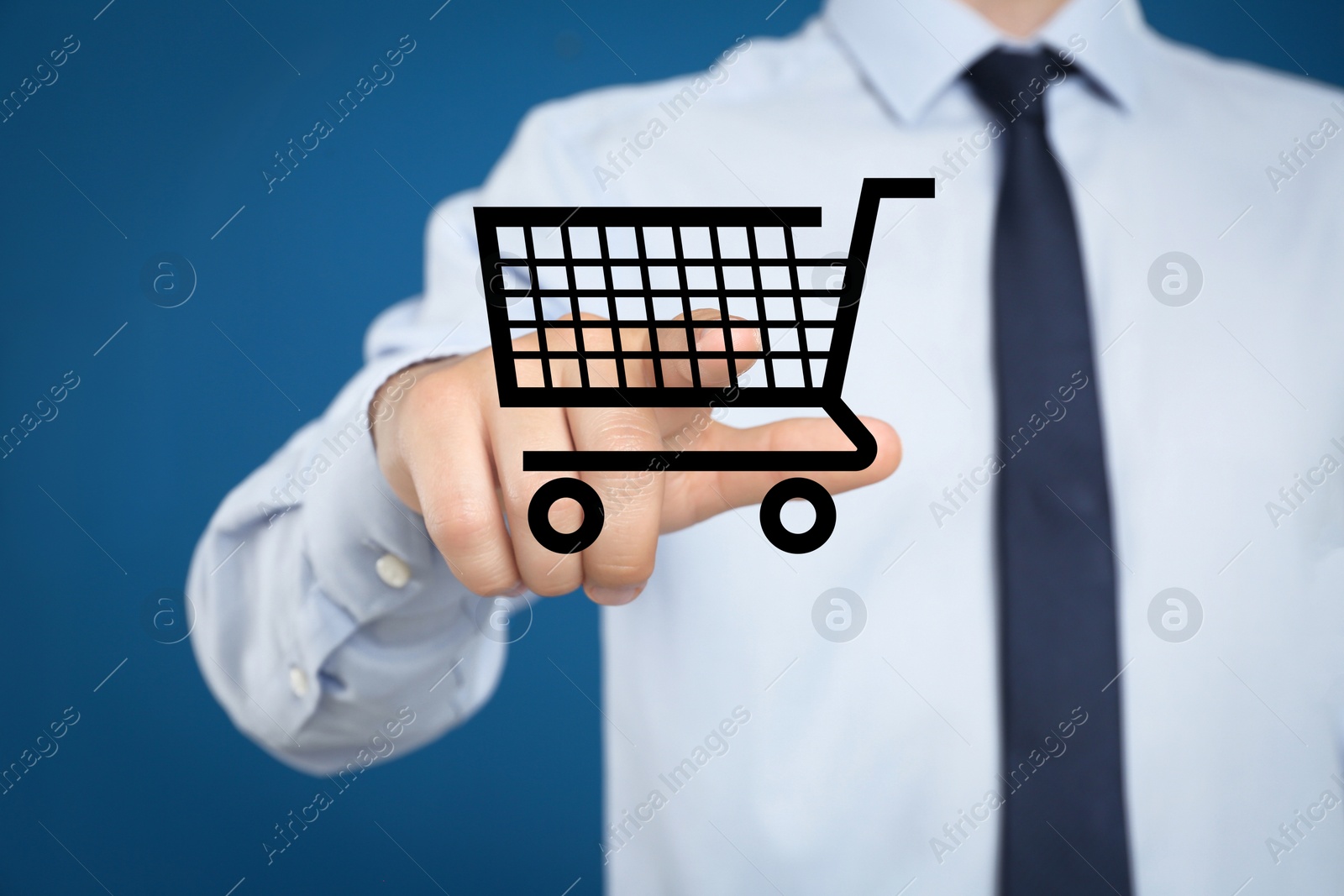 Image of Man demonstrating virtual image of shopping cart on blue background, closeup