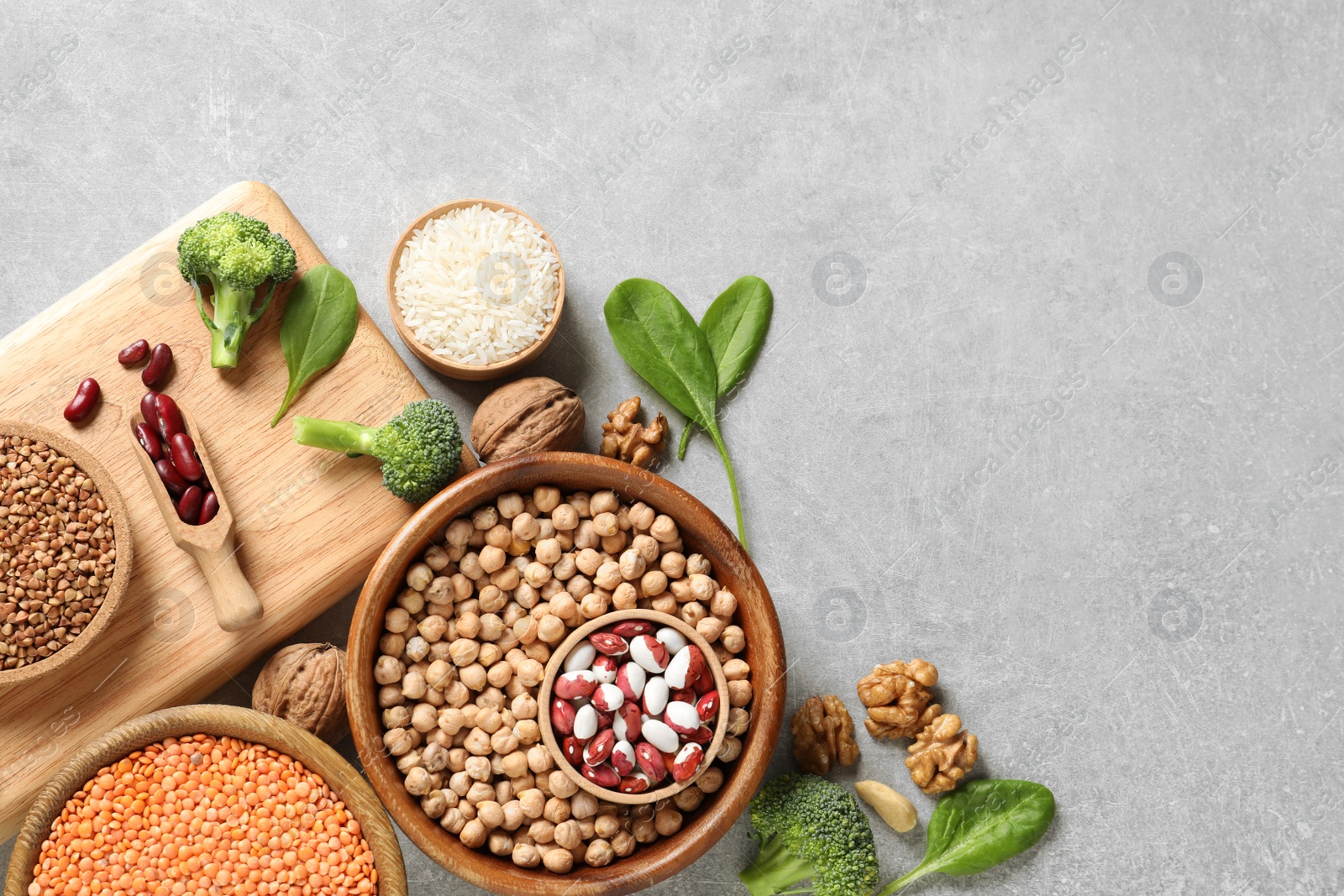 Photo of Set of natural food high in protein and space for text on grey background, top view