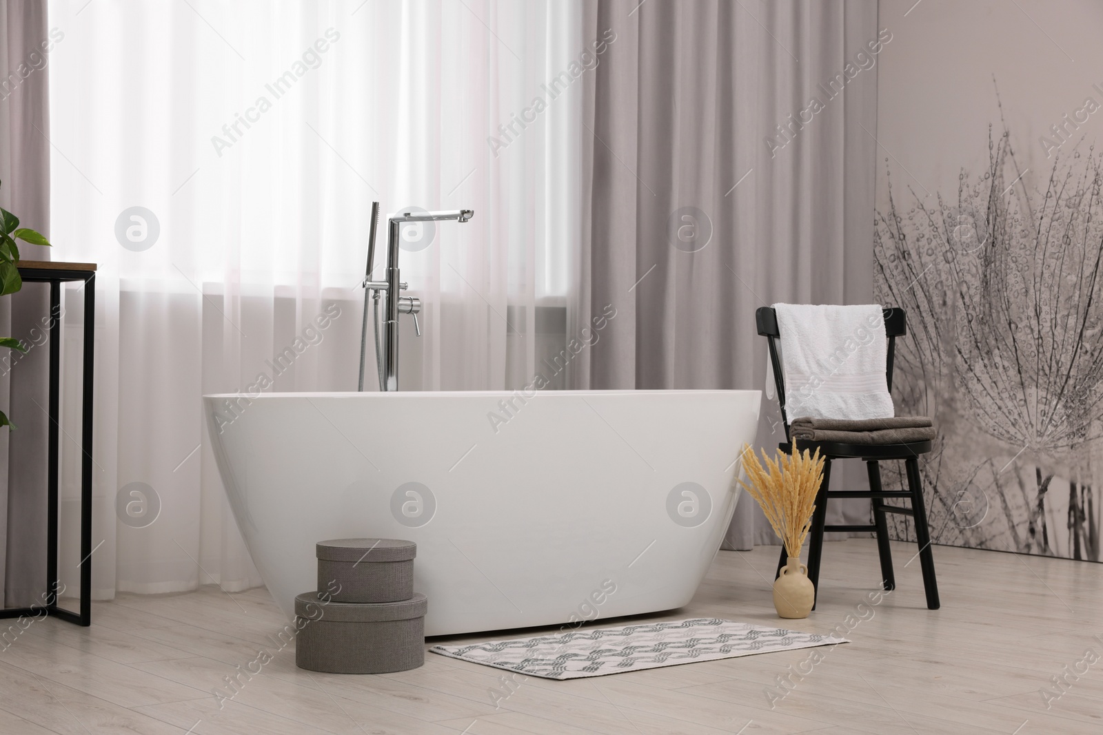 Photo of Stylish bathroom interior with soft bath mat and tub