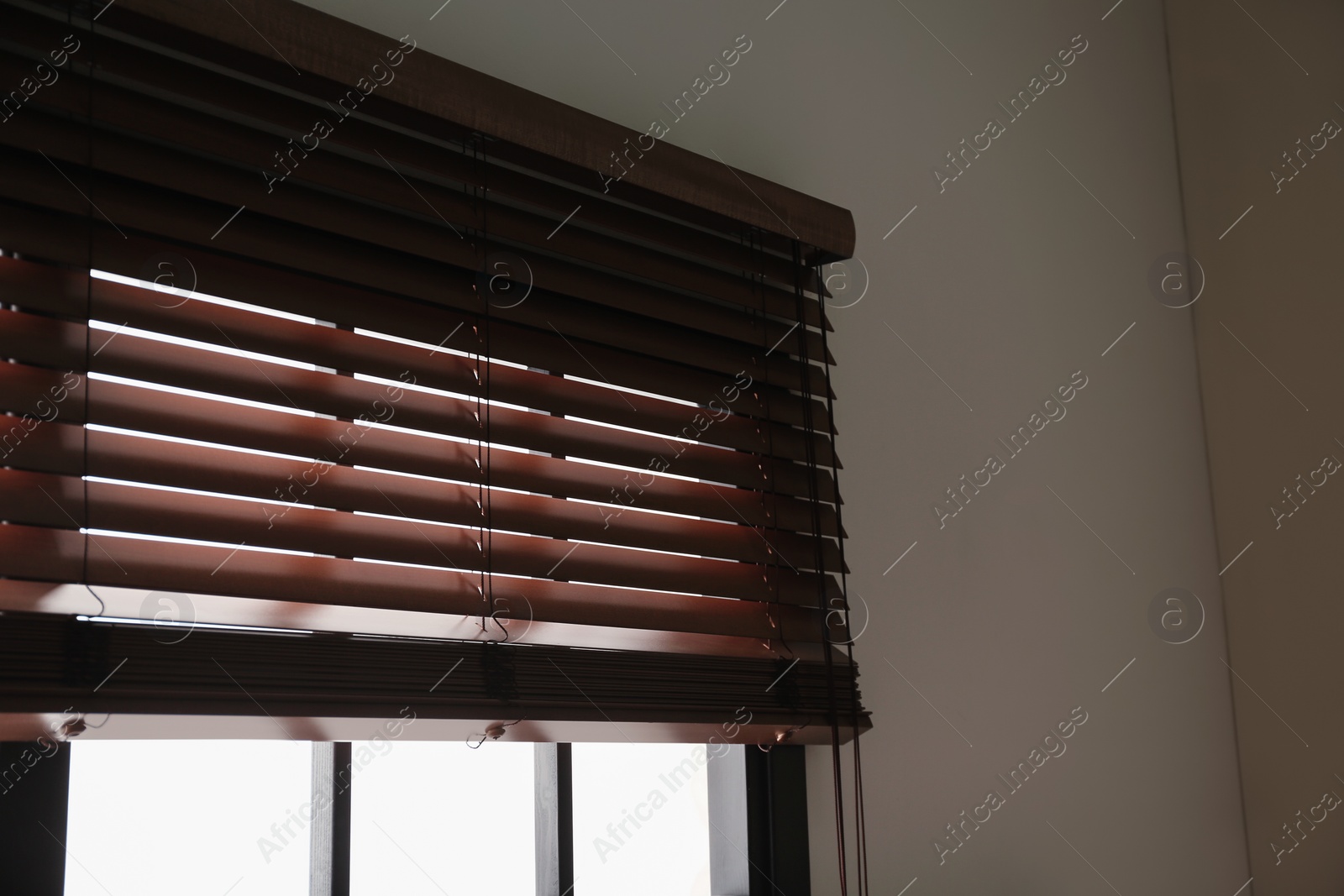 Photo of Modern window with stylish wooden blinds indoors