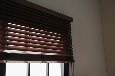 Photo of Modern window with stylish wooden blinds indoors