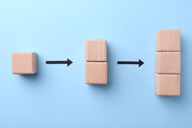 Photo of Business process organization and optimization. Scheme with wooden figures and arrows on light blue background, top view