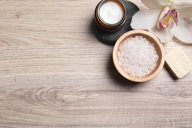 Photo of Flat lay composition with spa products and beautiful flower on light wooden table. Space for text