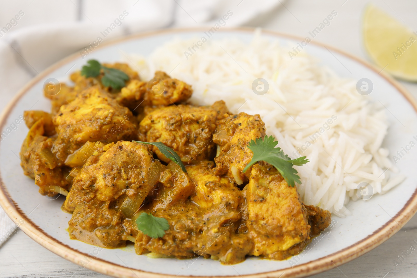 Photo of Delicious chicken curry with rice on table, closeup