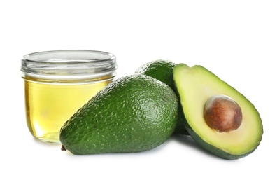 Jar of natural oil and avocados isolated on white