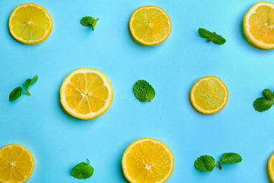 Photo of Lemonade layout with juicy lemon slices and mint on light blue background, top view