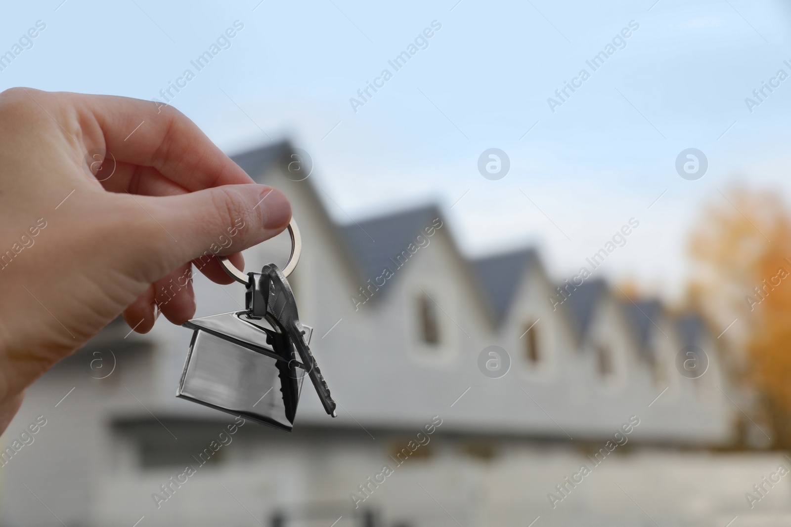 Photo of Woman holding house keys outdoors, closeup with space for text. Real estate agent