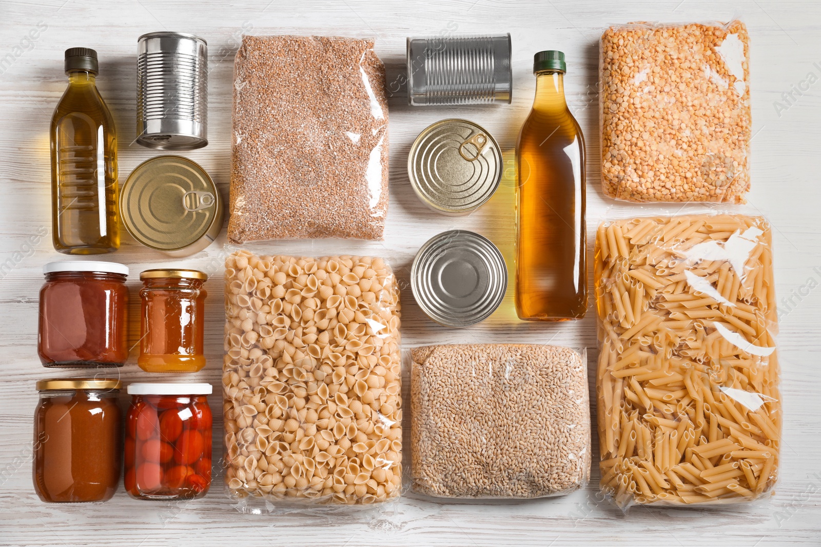 Photo of Different products on white wooden table, flat lay. Food donation