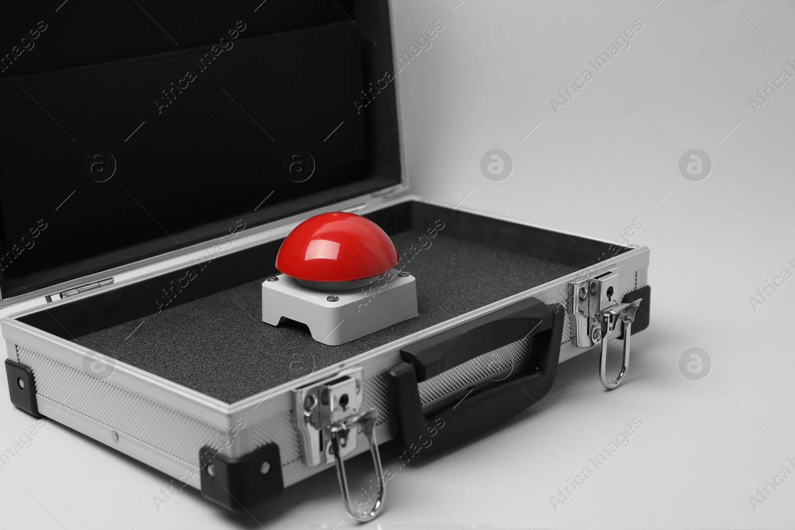 Photo of Red button of nuclear weapon in suitcase on white background. War concept