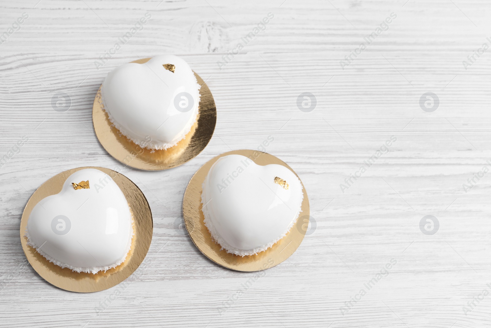 Photo of St. Valentine's Day. Delicious heart shaped cakes on white wooden table, flat lay. Space for text