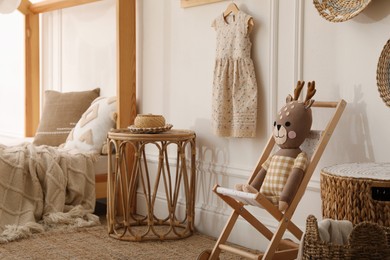 Photo of Deck chair with toy in child room. Interior design