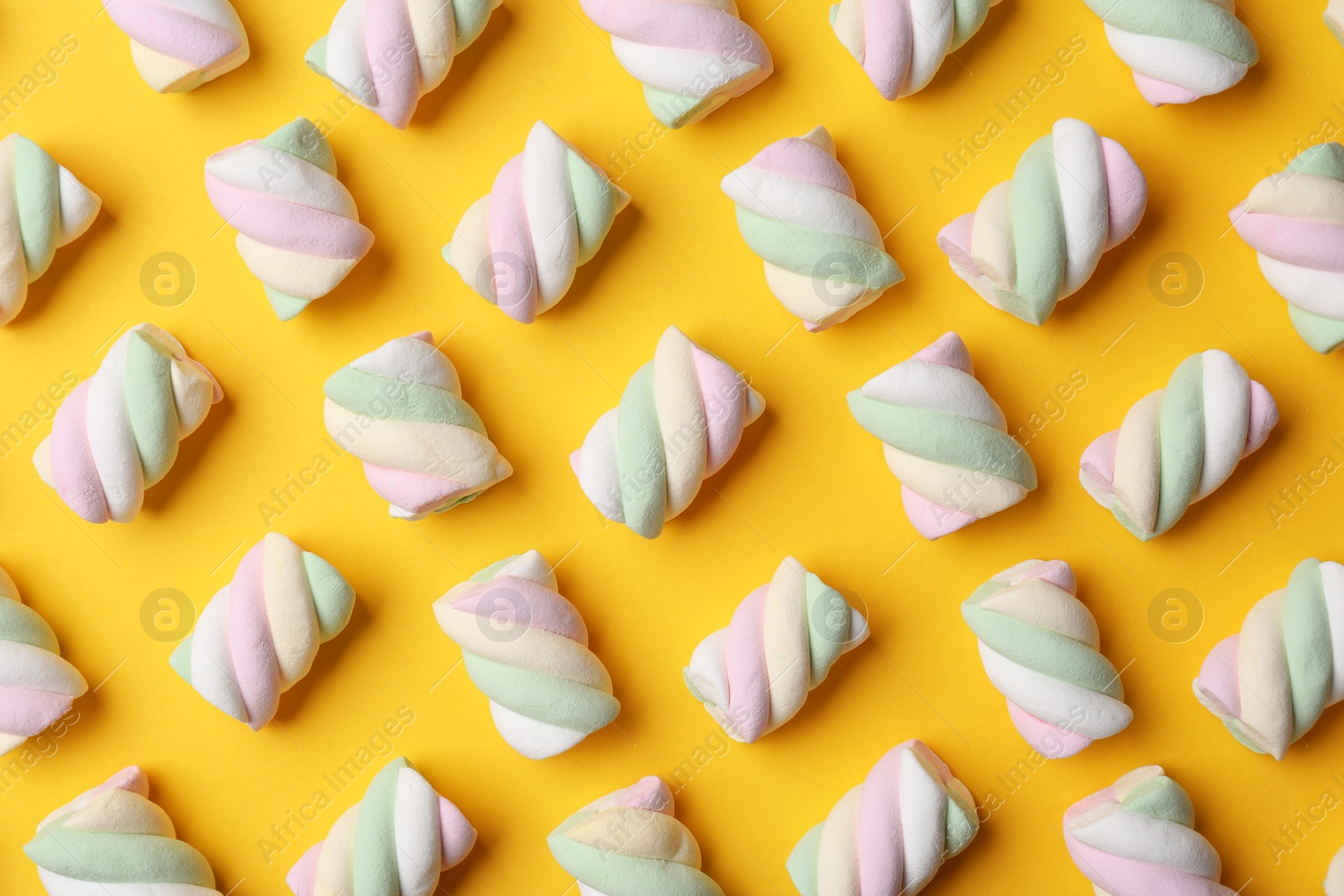 Photo of Delicious colorful marshmallows on yellow background, flat lay