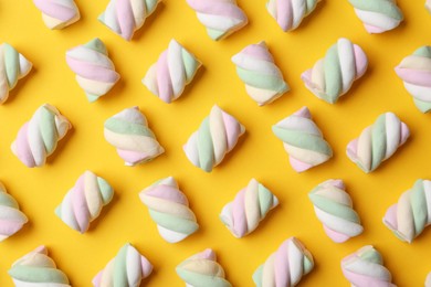 Photo of Delicious colorful marshmallows on yellow background, flat lay