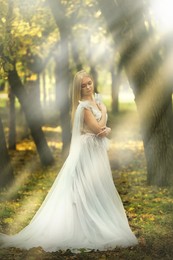 Photo of Beautiful girl wearing fairy dress in autumn forest