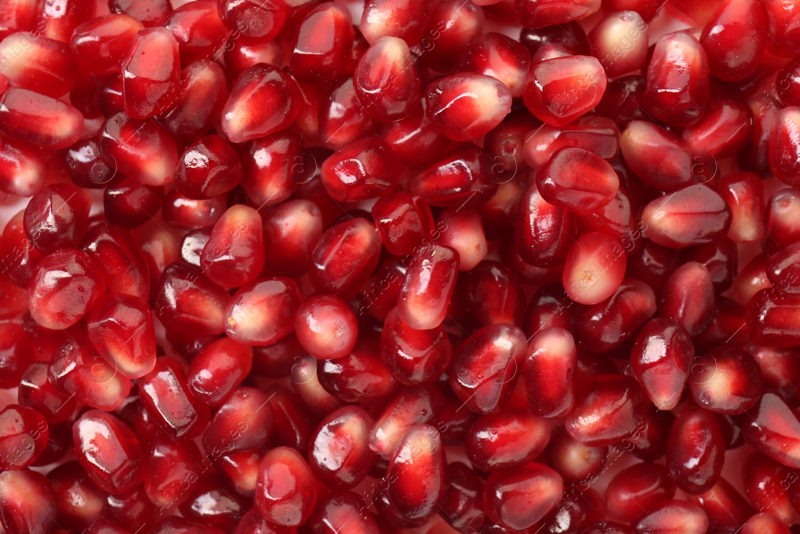 Photo of Ripe juicy pomegranate grains as background, top view