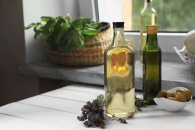 Different cooking oils and ingredients on white wooden table indoors