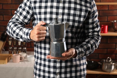 Photo of Man holding coffee moka pot in kitchen, closeup