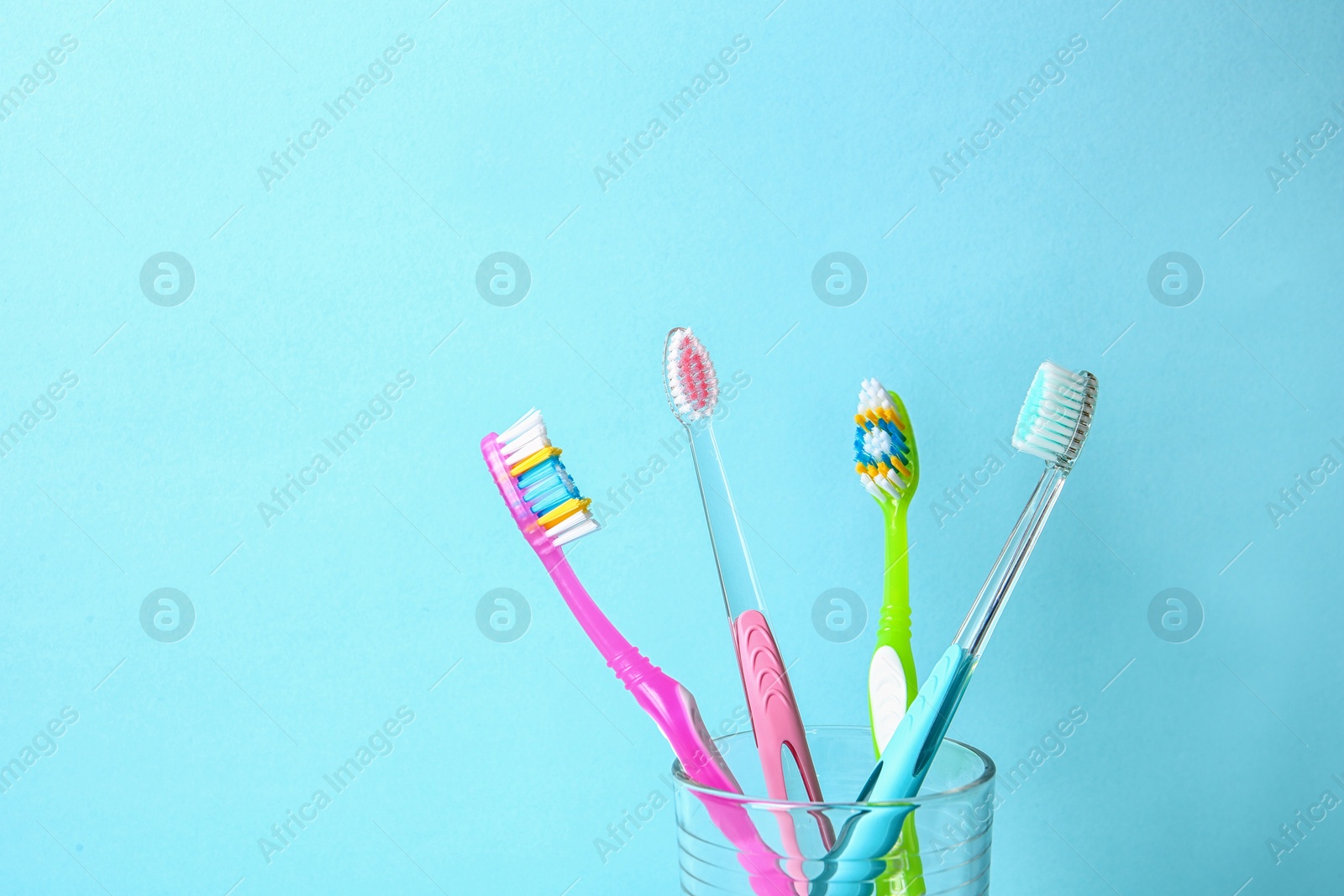 Photo of Cup with toothbrushes against color background. Dental care