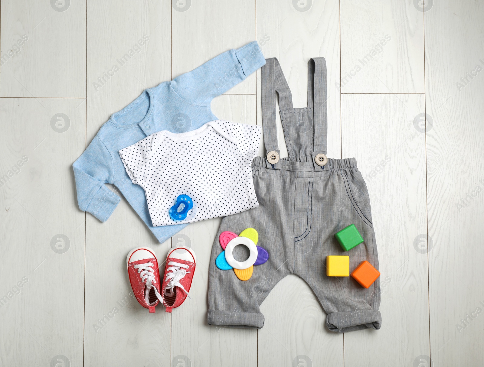 Photo of Flat lay composition with cute clothes on wooden background. Baby accessories