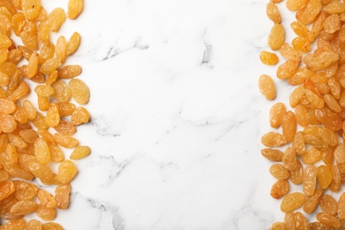 Photo of Many raisins and space for text on marble background, top view. Dried fruit as healthy snack